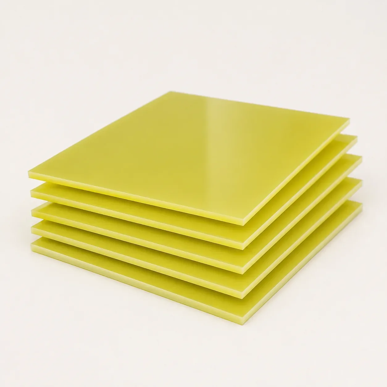 Yellow fiberglass epoxy garment template boards stacked in a neutral product studio